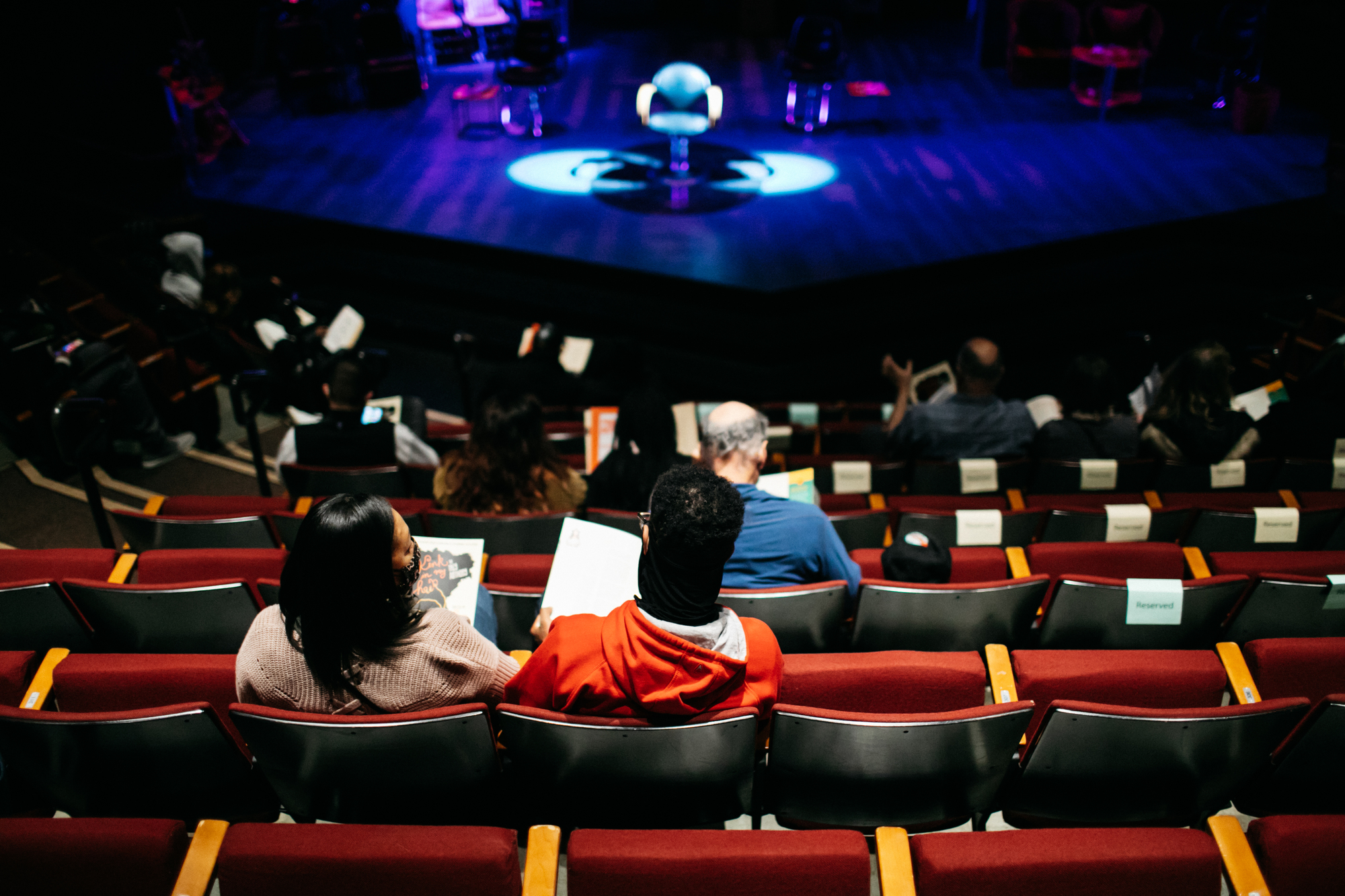 Audience in a theater, waiting for a play to begin.