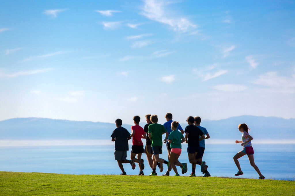 Students running on the East Field over looking the Monterey Bay.
